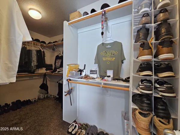 a view of walk in closet with clothes and shoes