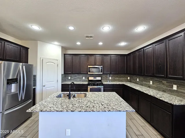 a kitchen with stainless steel appliances granite countertop a sink stove and refrigerator