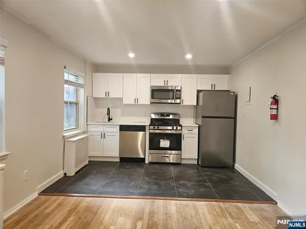 a kitchen with a refrigerator a stove top oven a sink and cabinets