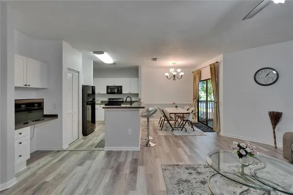 a kitchen with stainless steel appliances granite countertop a dining table chairs and chandelier
