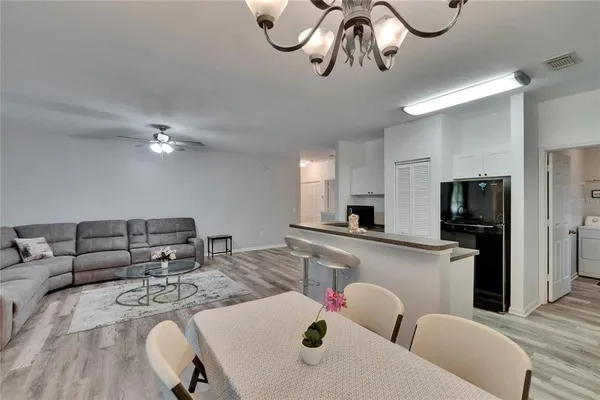 a kitchen that has a sink a microwave oven a stove and white cabinets with wooden floor