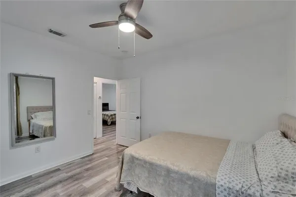 a bedroom with a large bed and a chandelier