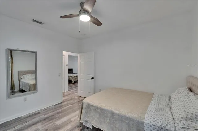 a bedroom with a large bed and a chandelier