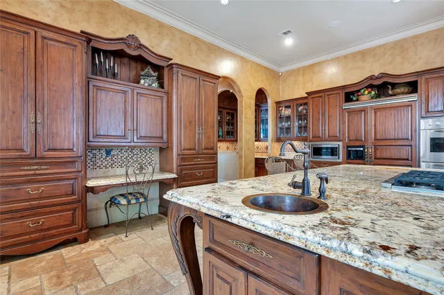 a kitchen with stainless steel appliances granite countertop a sink and a refrigerator
