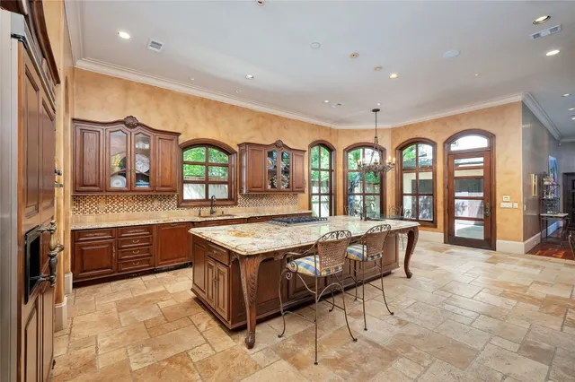 a large kitchen with stainless steel appliances granite countertop a stove and a large window