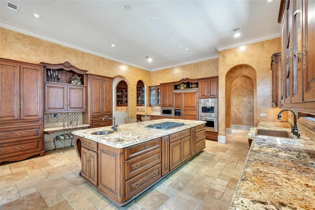 a large kitchen with stainless steel appliances granite countertop a large stove a sink dishwasher and cabinets with wooden floor