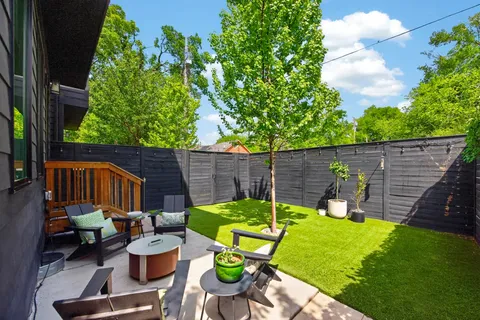 a view of a backyard with chairs potted plants and wooden fence