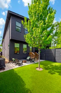 a view of a backyard with table and chairs and a tree