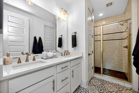 a bathroom with double vanity and a shower