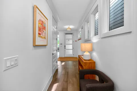 a hallway with a couch and dresser with wooden floor