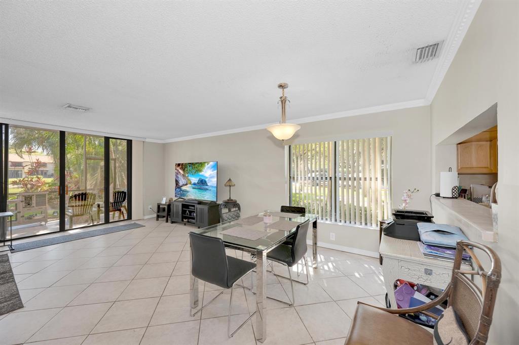 3963 Cocoplum Circle, Unit F Coconut Creek, FL 33063 - Photo 14 of 35 a living room with furniture and a flat screen tv