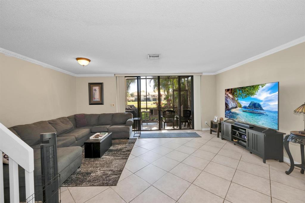 3963 Cocoplum Circle, Unit F Coconut Creek, FL 33063 - Photo 15 of 35 a living room with furniture and a flat screen tv