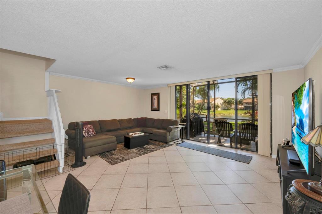 3963 Cocoplum Circle, Unit F Coconut Creek, FL 33063 - Photo 16 of 35 a living room with furniture and a flat screen tv