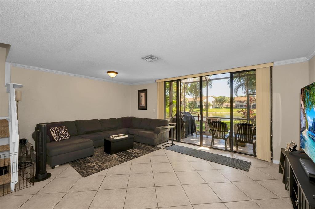3963 Cocoplum Circle, Unit F Coconut Creek, FL 33063 - Photo 18 of 35 a living room with furniture and large windows