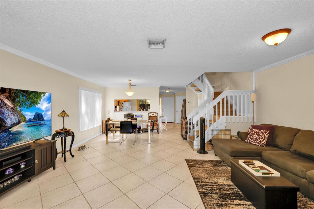 3963 Cocoplum Circle, Unit F Coconut Creek, FL 33063 - Photo 19 of 35 a living room with furniture and a flat screen tv