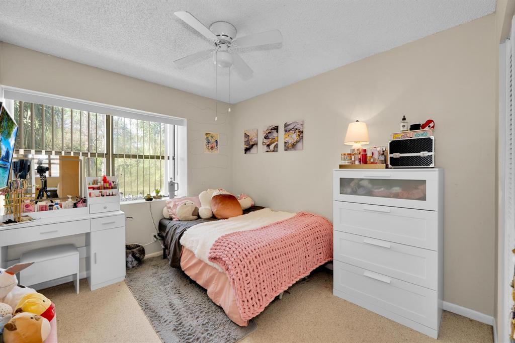 3963 Cocoplum Circle, Unit F Coconut Creek, FL 33063 - Photo 20 of 35 a bedroom with a bed and a window