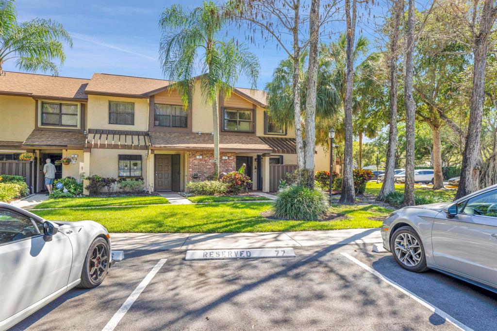 3963 Cocoplum Circle, Unit F Coconut Creek, FL 33063 - Photo 2 of 35 a view of a car park in front of a building
