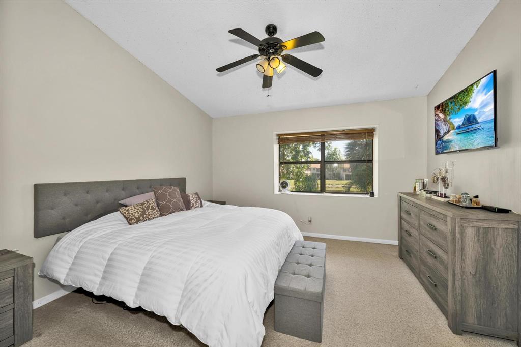 3963 Cocoplum Circle, Unit F Coconut Creek, FL 33063 - Photo 24 of 35 a bedroom with a bed and a window