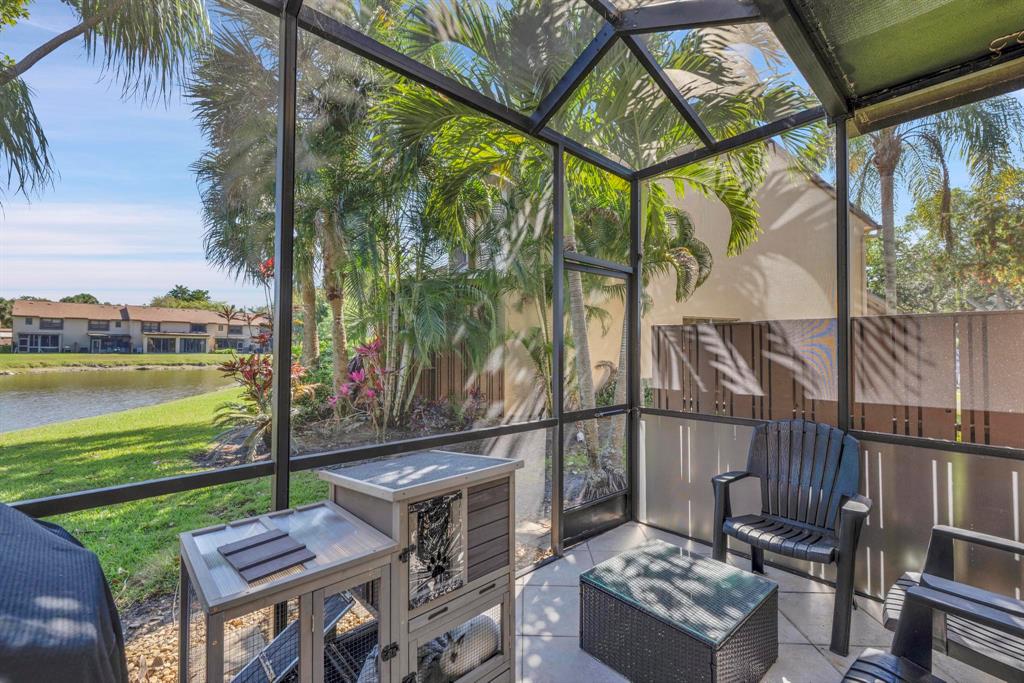 3963 Cocoplum Circle, Unit F Coconut Creek, FL 33063 - Photo 28 of 35 a view of a chairs and table in patio with a lake view