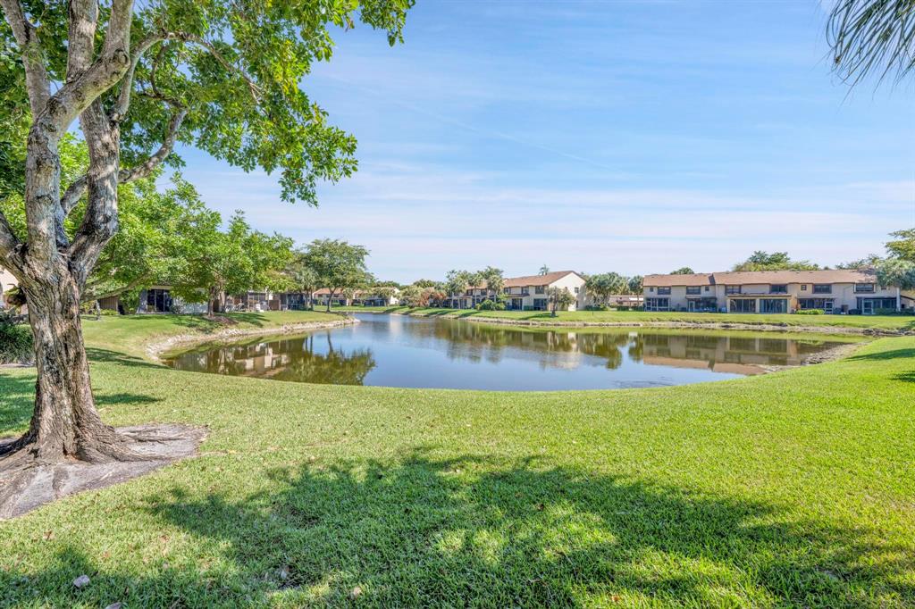 3963 Cocoplum Circle, Unit F Coconut Creek, FL 33063 - Photo 31 of 35 a view of a lake with houses in the back