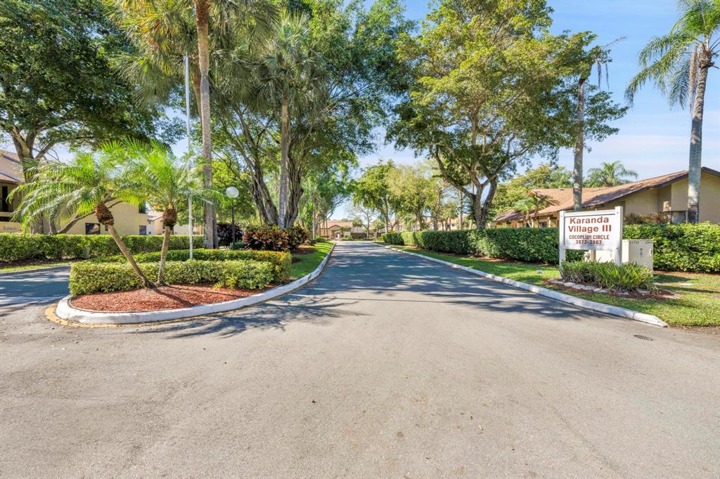 3963 Cocoplum Circle, Unit F Coconut Creek, FL 33063 - Photo 34 of 35 a view of a house with a yard and plant on road