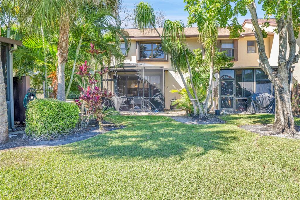 3963 Cocoplum Circle, Unit F Coconut Creek, FL 33063 - Photo 6 of 35 a view of a house with a backyard and a tree