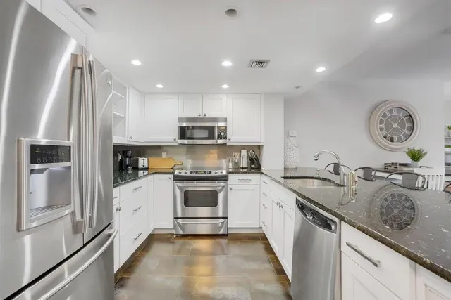 a kitchen with stainless steel appliances granite countertop a sink stove oven and refrigerator
