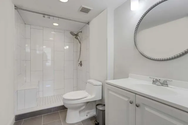 a bathroom with a sink a toilet and shower