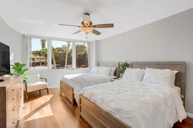 a large white bed in a bedroom next to a window
