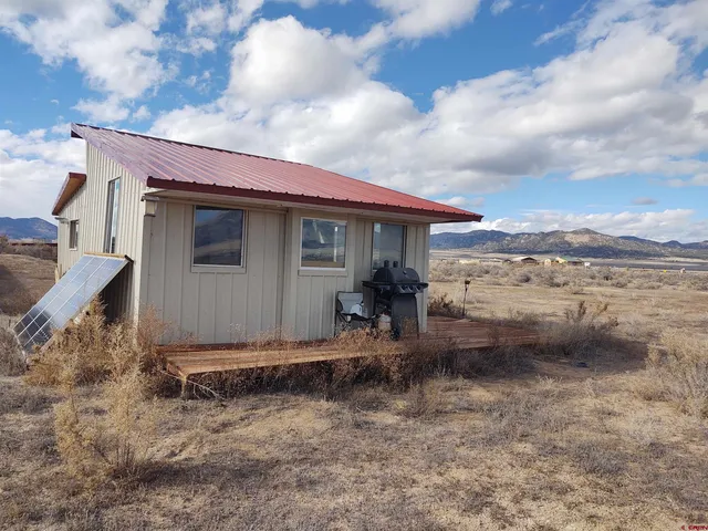 a backyard of a house with table and chairs