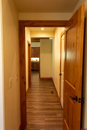 a view of a hallway with wooden floor and staircase