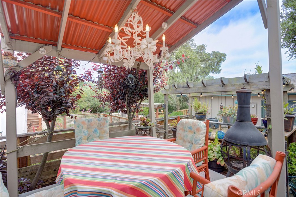 1675 Los Osos Valley Road, Unit 223 Los Osos, CA 93402 - Photo 12 of 68 a view of a patio with table and chairs potted plants and large tree