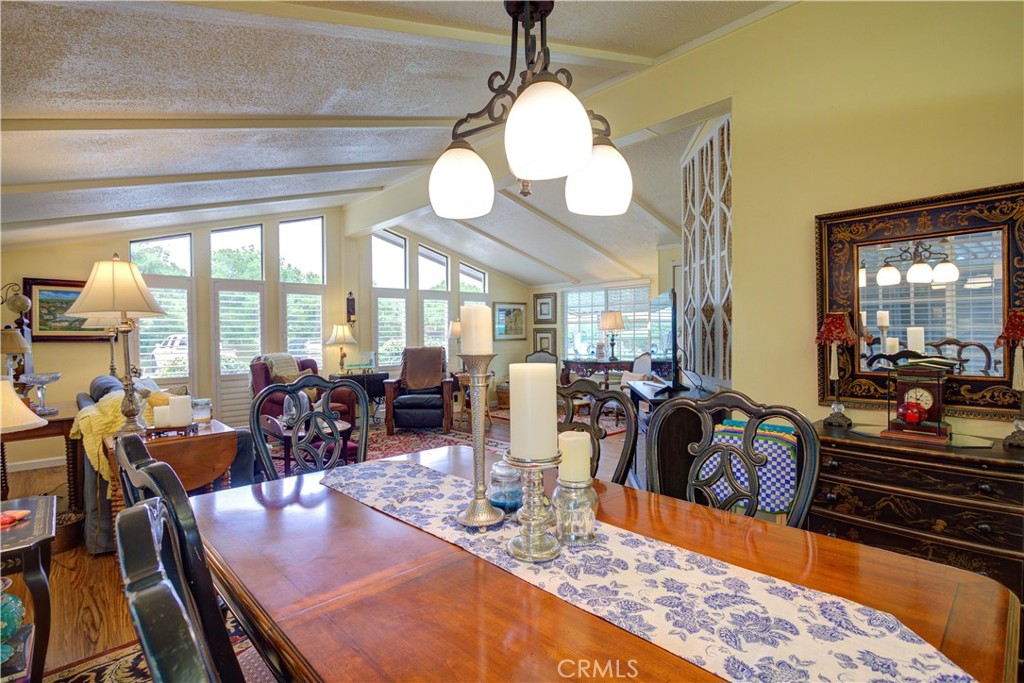 1675 Los Osos Valley Road, Unit 223 Los Osos, CA 93402 - Photo 23 of 68 a view of a dining room and hall with furniture wooden floor and a chandelier