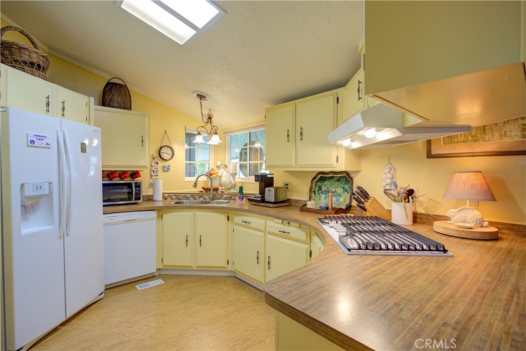 1675 Los Osos Valley Road, Unit 223 Los Osos, CA 93402 - Photo 28 of 68 a kitchen with stainless steel appliances granite countertop a sink a stove and a refrigerator