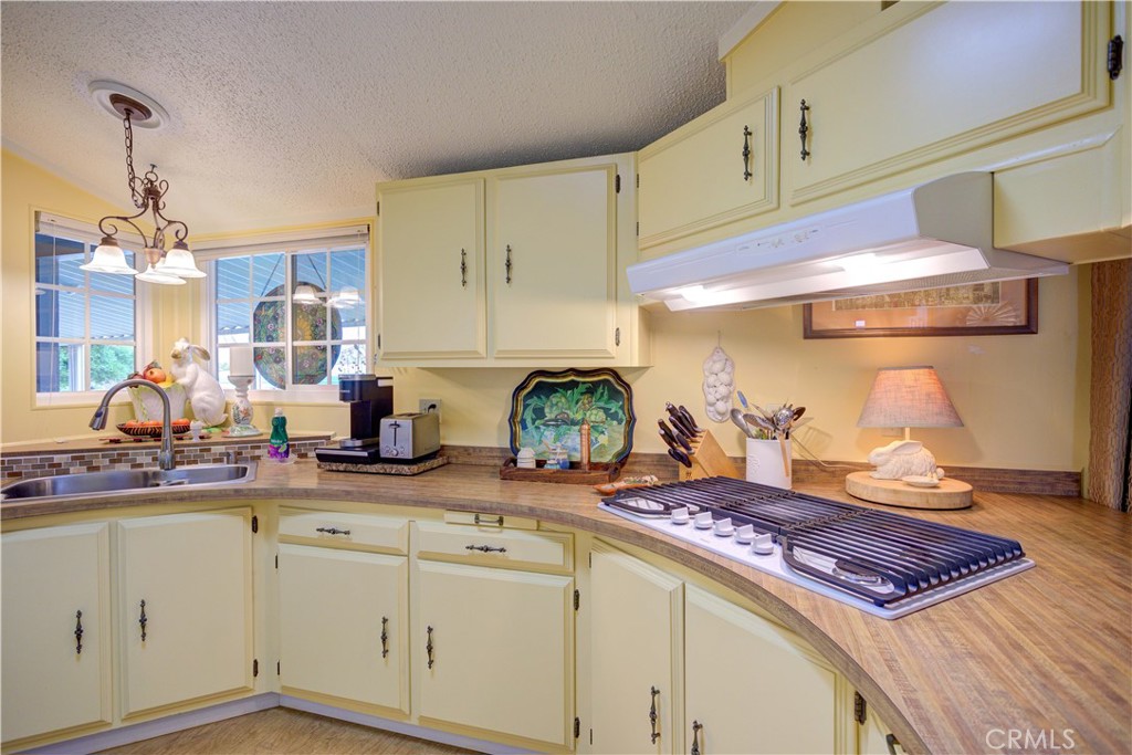 1675 Los Osos Valley Road, Unit 223 Los Osos, CA 93402 - Photo 29 of 68 a kitchen with kitchen island granite countertop stove top oven and cabinets