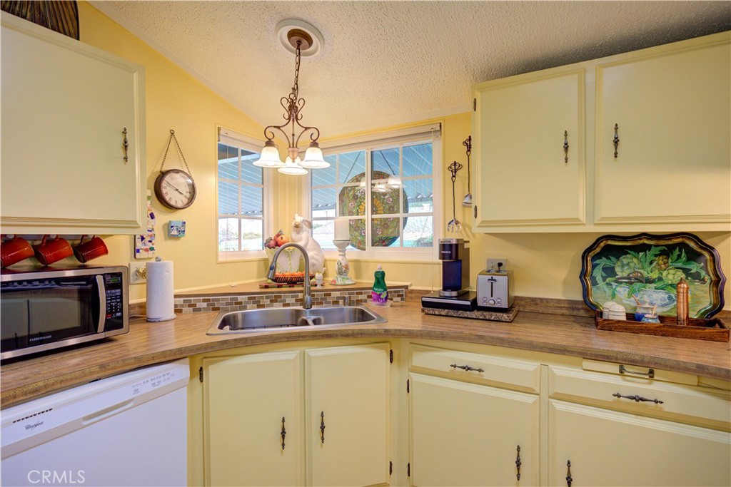 1675 Los Osos Valley Road, Unit 223 Los Osos, CA 93402 - Photo 32 of 68 a kitchen with stainless steel appliances a sink and a stove top oven