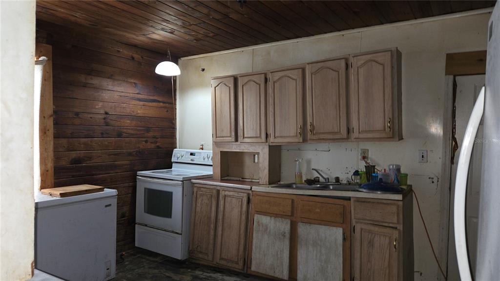 883 Northeast Maple Lane Lake City, FL 32055 - Photo 11 of 14 a kitchen with stainless steel appliances granite countertop a stove a refrigerator and cabinets