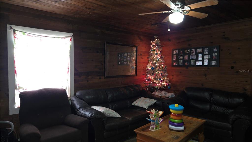 883 Northeast Maple Lane Lake City, FL 32055 - Photo 3 of 14 a living room with furniture a chandelier and a window