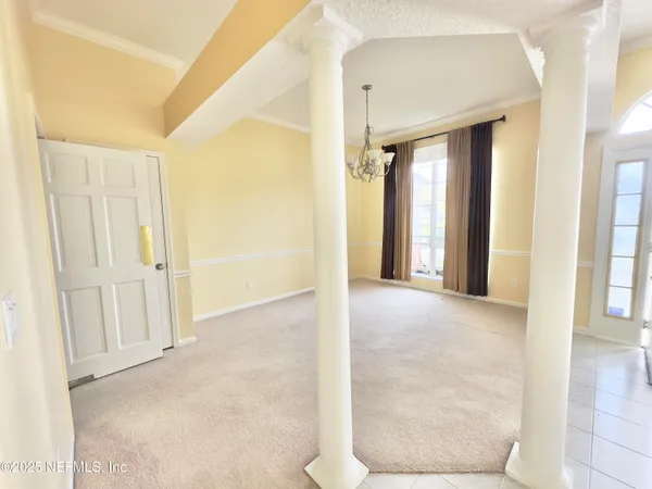 a view of a big room with windows and chandelier fan