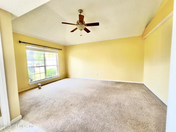 a view of a livingroom with a ceiling fan and window