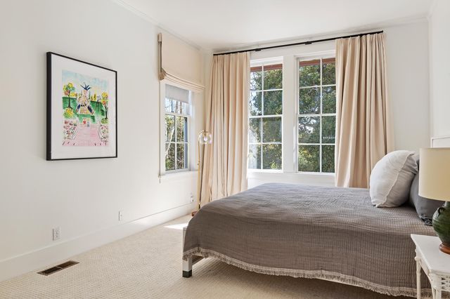 a bedroom with a bed and painting on the wall