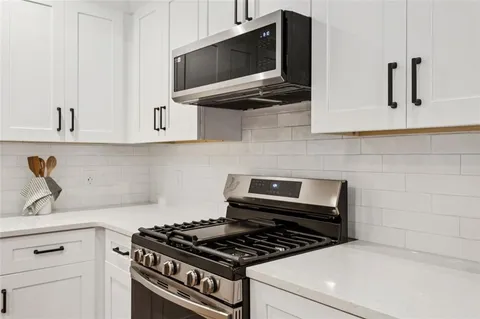 a kitchen with stainless steel appliances a stove and a microwave