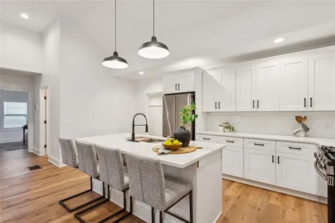 a kitchen with a dining table chairs refrigerator and cabinets