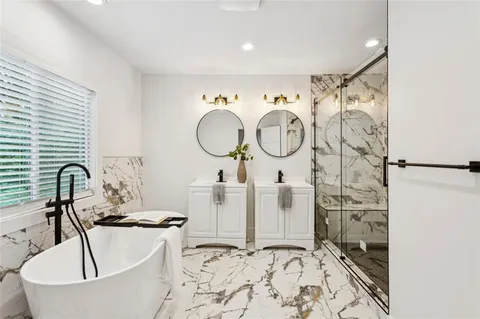 a bathroom with a bathtub sink and mirror