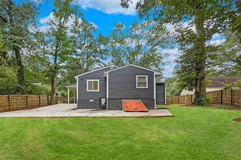 a view of a house with a backyard and floor to ceiling window