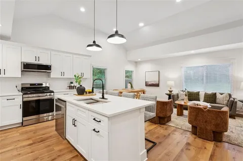 a kitchen that has a lot of cabinets a sink and a stove in it