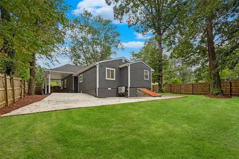 a front view of a house with a yard and trees