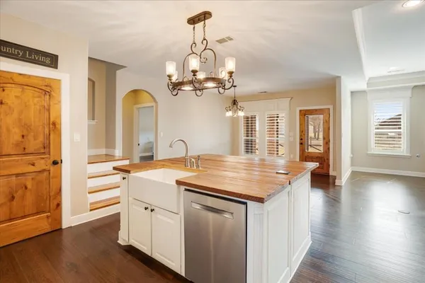 a kitchen with granite countertop white cabinets and a stainless steel appliances