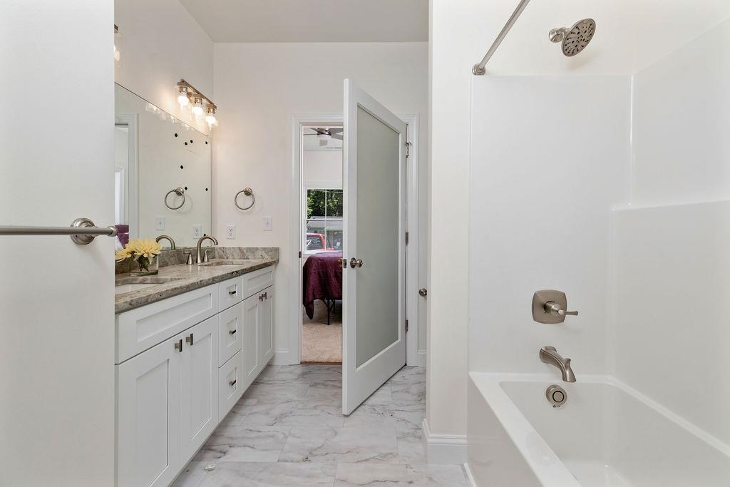 833 Faber Avenue Waynesboro, VA 22980 - Photo 16 of 36 a bathroom with a granite countertop sink a mirror and a bathtub