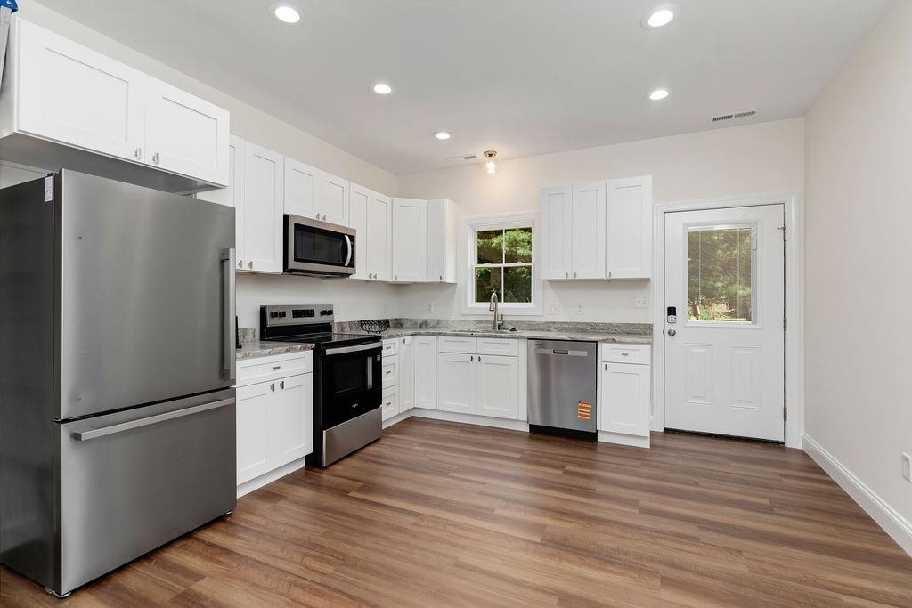 833 Faber Avenue Waynesboro, VA 22980 - Photo 4 of 36 a kitchen with a refrigerator a stove top oven a sink and dishwasher with wooden floor